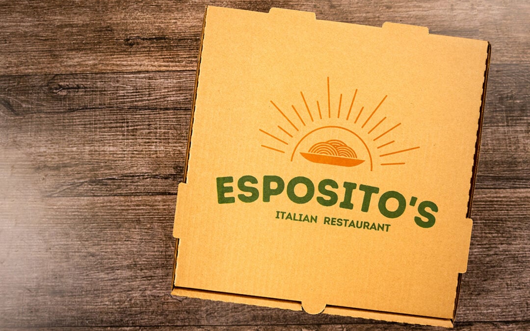 A pizza box that reads "Esposito's Italian Restaurant" on a wooden table.