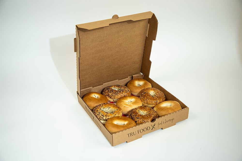 Pizza box with nine bagels.