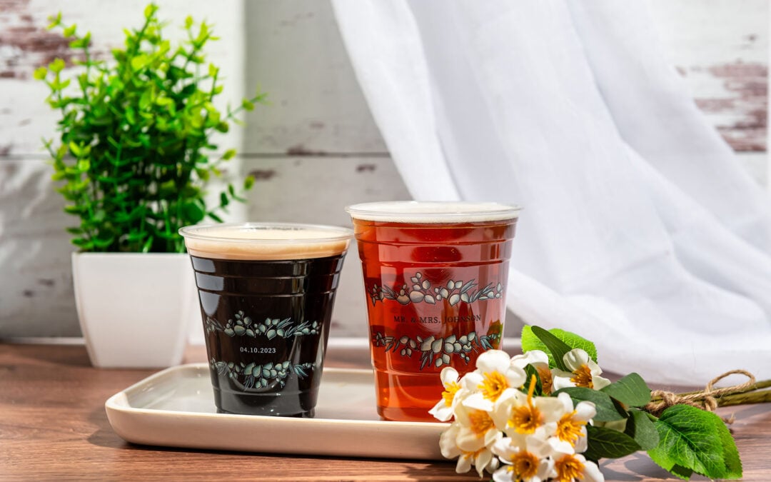 Two plastic cups with stock wedding designs.