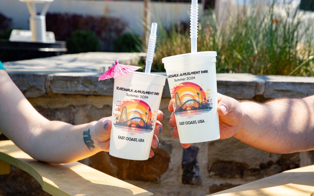 Hands "cheers" two custom printed stadium cups.