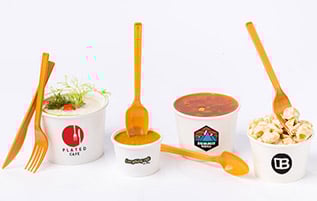 A line of 4 custom printed soup cups filled with 3 soups and 1 pasta salad.